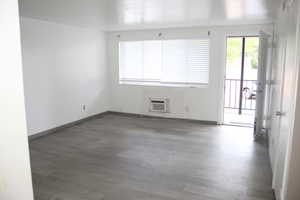 Spare room with a wall mounted air conditioner and hardwood / wood-style floors