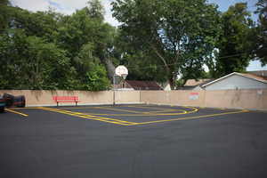 View of parking featuring basketball court