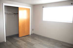 Unfurnished bedroom featuring a closet and hardwood / wood-style flooring