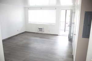 Unfurnished room featuring a wall unit AC and hardwood / wood-style flooring