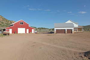 View of yard with an outdoor structure, a mountain view, and a garage