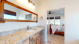 Bathroom with ceiling fan and vanity with extensive cabinet space