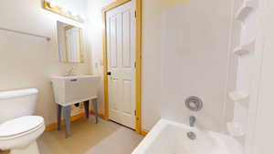 Bathroom with toilet and bathing tub / shower combination