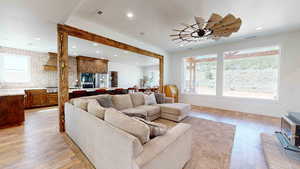 Living room with light hardwood / wood-style floors and ceiling fan