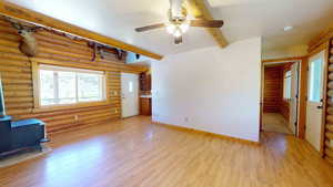 Unfurnished living room with light wood-type flooring and log walls