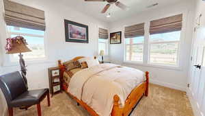 Carpeted bedroom featuring ceiling fan