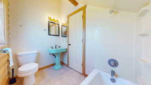 Bathroom featuring bathtub / shower combination, tile floors, and toilet