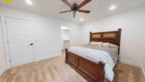 Carpeted bedroom with a closet and ceiling fan