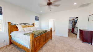 Carpeted bedroom featuring ceiling fan and a closet