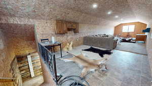 Bedroom with light tile floors and lofted ceiling