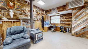 Misc room featuring wood walls and a wood stove