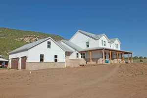 View of front of property with a garage, a mountain view, and covered porch