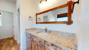 Bathroom featuring plenty of natural light, vanity, and hardwood / wood-style flooring