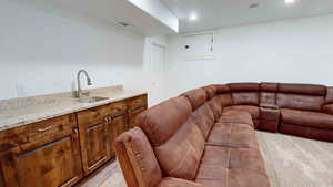 Living room featuring sink and light colored carpet