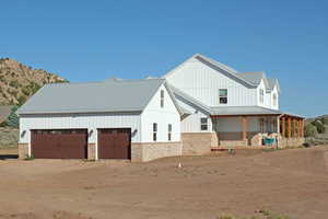 Exterior space with a garage, a mountain view, and a porch