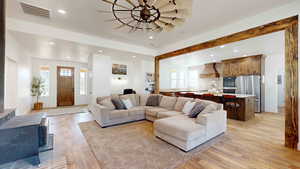 Living room with a healthy amount of sunlight and light hardwood / wood-style floors