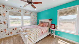 Carpeted bedroom featuring ceiling fan