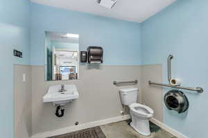 Bathroom featuring sink, toilet, and tile floors