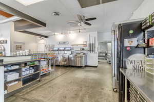 Interior space with ceiling fan and concrete flooring