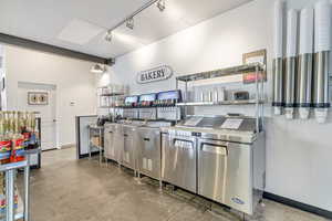 Kitchen featuring concrete floors, stainless steel counters, and track lighting