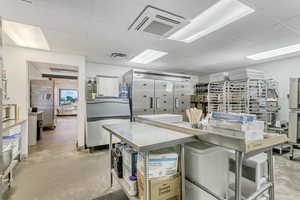 Kitchen featuring concrete floors, stainless steel counters, and stainless steel refrigerator
