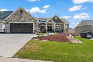 Craftsman inspired home featuring a front lawn, a garage, and a porch