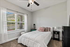 Bedroom with dark carpet and ceiling fan