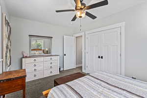 Carpeted bedroom featuring a closet and ceiling fan