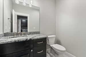 Bathroom featuring vanity, toilet, and tile floors