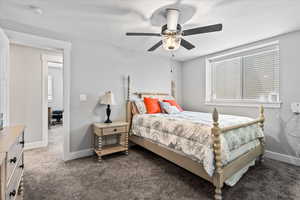 Carpeted bedroom with multiple windows and ceiling fan