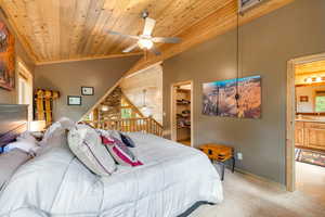 Carpeted bedroom featuring a spacious closet, wood ceiling, ensuite bath, and ceiling fan