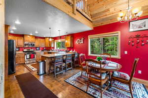 Dining area with sink, an inviting chandelier, a textured ceiling, and hardwood / wood-style floors