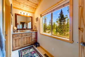 Bathroom with wooden ceiling, vanity, lofted ceiling, and plenty of natural light