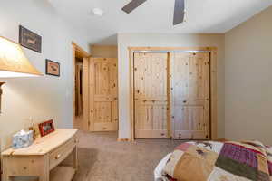 Carpeted bedroom featuring ceiling fan