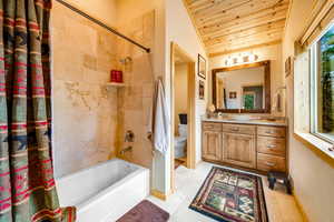 Full bathroom with toilet, wood ceiling, vanity, tile patterned floors, and vaulted ceiling