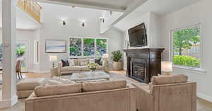 Living room featuring vaulted ceiling with beams and a healthy amount of sunlight