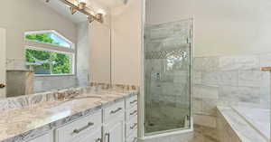 Bathroom with vanity, plus walk in shower, and lofted ceiling