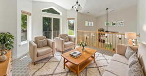 Living room with ceiling fan with notable chandelier, high vaulted ceiling, and a healthy amount of sunlight