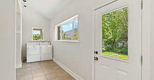 Laundry room featuring light tile patterned flooring and washing machine and dryer