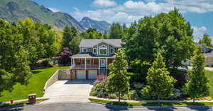 View of front of home with a mountain view, a front yard, and a garage