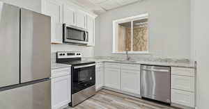 Kitchen featuring sink, stainless steel appliances, and white cabinets