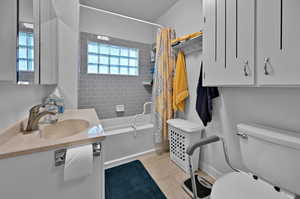 Full bathroom featuring shower / tub combo, tile patterned flooring, toilet, and vanity