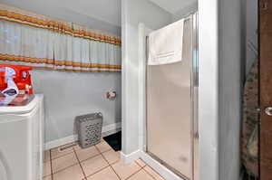 Bathroom with an enclosed shower and tile patterned flooring