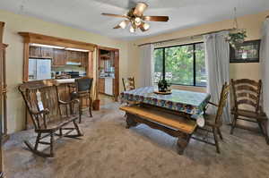 Carpeted dining area with ceiling fan