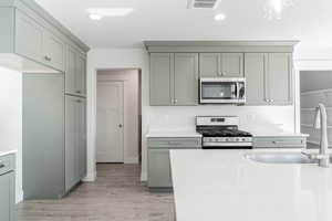 Kitchen featuring light wood-type flooring, sink, and stainless steel appliances