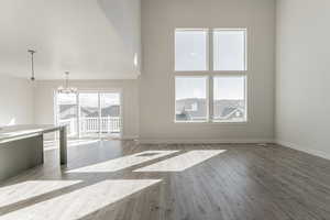 Unfurnished living room with an inviting chandelier and light hardwood / wood-style flooring