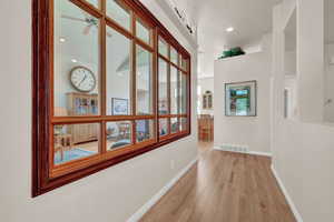 Corridor with light hardwood / wood-style flooring