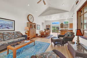 Living room with high vaulted ceiling, ceiling fan, and light wood-type flooring