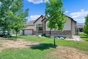 View of front of home featuring a front yard and a garage