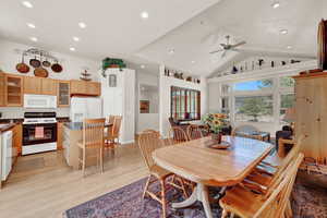 Dining area featuring light hardwood / wood-style floors, ceiling fan, and vaulted ceiling